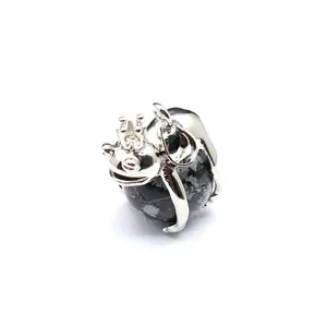 Close-up detail of a silver frog prince pendant clutching a natural stone sphere jewelry