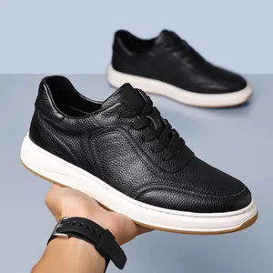 Detail of men's black pebbled leather casual sneakers with white soles