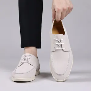 Macro detail view of cream suede casual loafers with white soles and lace-up design