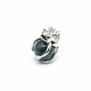 Detailed shot of silver frog prince pendant clutching a dark green stone ball.