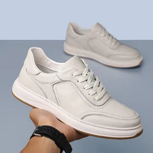 Macro view of white cowhide leather leisure shoe held by hand showing premium texture