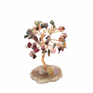Macro detail of handmade chakra stone wire tree on a natural polished agate slice base