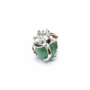 Detailed macro view of a silver frog prince pendant holding a green natural stone bead