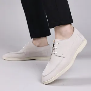 Close-up detail of men's beige suede casual shoes with white laces and sole