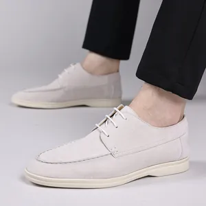 Close-up detail of off-white suede casual shoes with white laces and flat soles