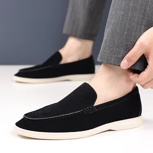 Close-up of black suede men's loafers with a white sole and slip-on design