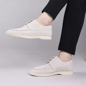 Side view detail of men's beige suede casual lace-up shoes worn with black trousers