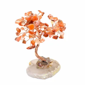 Handmade wire-wrapped gemstone tree with orange carnelian chips on agate slice base.