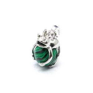 Detailed macro view of a silver frog pendant clutching a green malachite stone ball