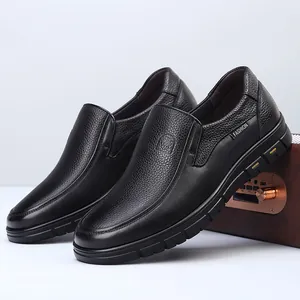 Close-up of black genuine cowhide leather men's slip-on loafers showing premium texture
