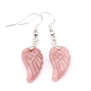 Primer plano de pendientes de ala en piedra natural rosa con ganchos