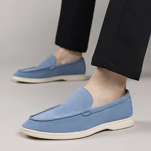Close-up detail of blue suede loafers for men styled with professional black trousers.