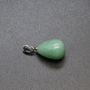 Macro detail of a green teardrop-shaped natural stone pendant with a polished silver bail.