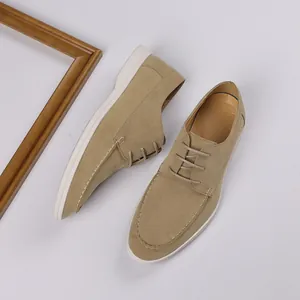 Detailed top-down view of men's beige suede loafers with white soles and laces