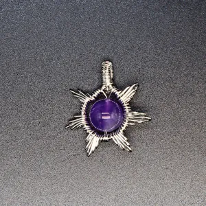 Detail showing hand-woven silver wire wrapping around a purple natural stone pendant