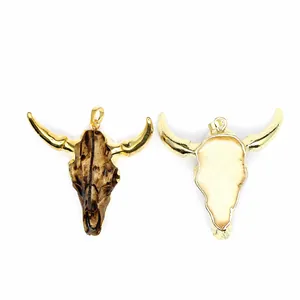 Detalle de un colgante de cabeza de toro para hombre de resina con baño de oro y textura.
