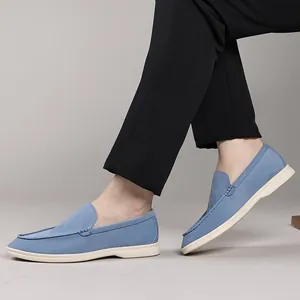 Side view of stylish blue suede loafers for men shown worn with elegant black trousers