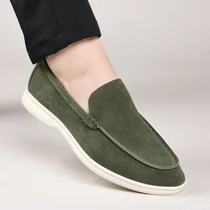 Detail view of men's premium green suede loafers with stylish white rubber soles.