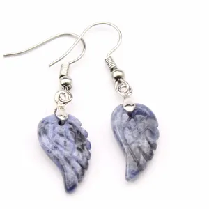 Primer plano de pendientes artesanales de labradorita azul con diseño de ala tallada
