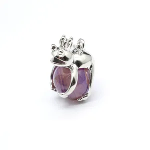 Macro detail of silver frog prince pendant holding purple striped stone