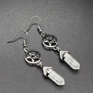 Close-up of silver-tone pentagram earrings featuring white hexagonal stone pendants.