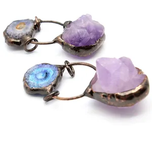 Makro-Detail von natürlichem Amethyst-Rohstein und blauem Solar-Achat-Kristall-Anhänger