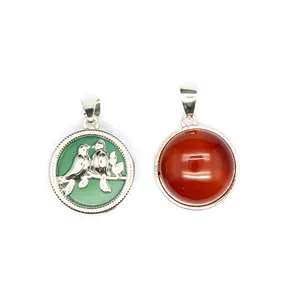Vue détaillée d'un pendentif en agate rouge naturelle et d'un pendentif oiseau vert.