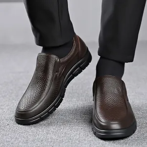 Dettaglio di scarpe slip-on da uomo in pelle martellata marrone con suola morbida nera