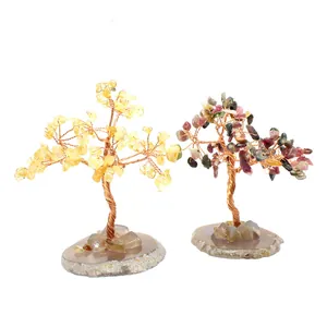 Detailed view of two handmade chakra gemstone wire trees on natural agate slice bases