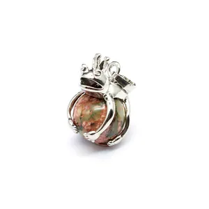 Professional detail shot of a silver frog prince pendant holding a round natural stone ball.