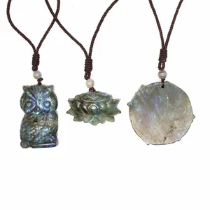 Detail view of natural labradorite pendants in owl and lotus shapes