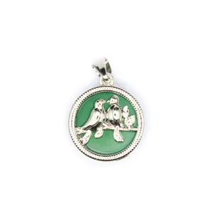 Vue détaillée d'un pendentif rond en argent avec un oiseau sur une pierre naturelle verte