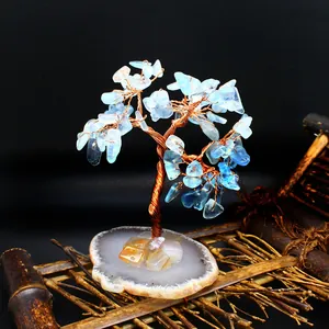 Detailed view of a handmade copper wire tree with blue crystal shards on an agate base