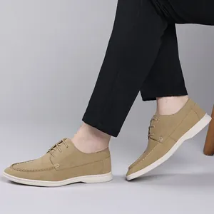 Detail view of men's tan suede lace-up casual shoes with white rubber soles.