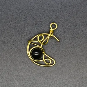 Close-up of handmade wire wrapped moon pendant featuring a smooth black onyx stone.
