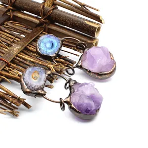 Nahaufnahme von Anhängern aus Amethyst-Rohkristall und Solar-Achat-Naturstein