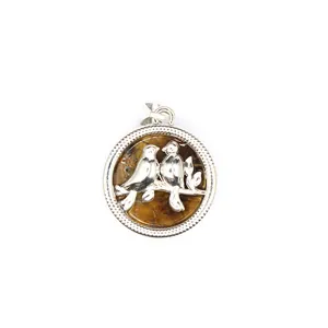 Vue détaillée d'un pendentif oiseaux en argent avec incrustation de pierre naturelle.