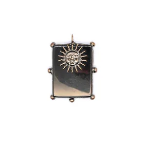 Vue détaillée d'un pendentif soleil en cuivre antique avec pierre naturelle noire