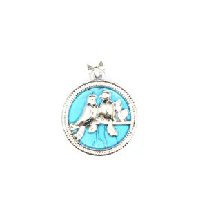 Détail en gros plan d'un pendentif oiseau en argent avec pierre turquoise