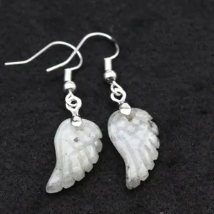 Detalle de pendientes artesanales de piedra labradorita con forma de alas de ángel