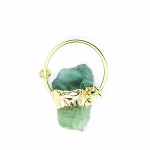 Detailed close-up view of a raw green crystal stone pendant with textured gold band
