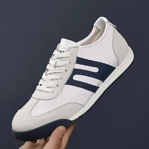 Side view showing the suede and leather details of white navy men's GAT sneakers