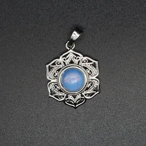 Détail d'un pendentif floral en argent serti d'une perle de cristal bleu clair.