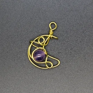 Detailed view of handmade gold wire wrapped moon pendant with amethyst purple stone