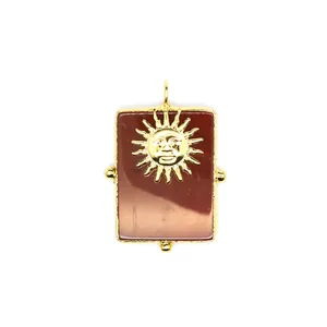 Détail macro du pendentif en pierre naturelle orné d'un motif soleil vintage doré