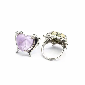 Dettaglio macro di un anello regolabile in ametista a forma di cuore con delfini