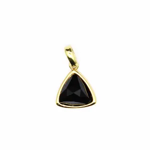 Macro view of a black faceted triangular gemstone pendant with gold bezel finish