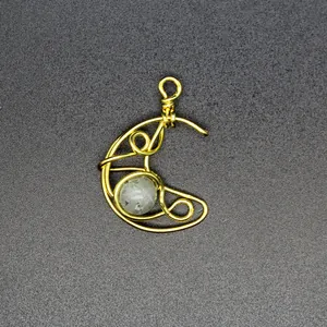 Detailed macro view of hand-woven wire-wrapped moon pendant with natural gemstone