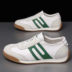Macro view of white leather men's sneakers with green stripe detail and gum soles
