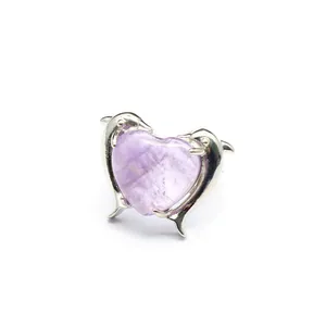 Primo piano di anello in ametista a cuore con due delfini che abbracciano la pietra